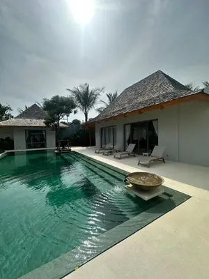 a swimming pool in front of a house at Anchan Tropicana By Ere in Ban Phru Champa
