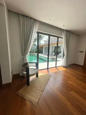 a living room with a table and a pool at Anchan Tropicana By Ere in Ban Phru Champa