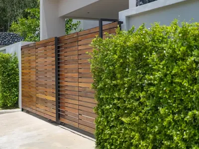 a wooden fence with bushes in front of a house at NEW Cozy 3BR Luxury Pool Villa - Villa Nova in Ban Pak Lak