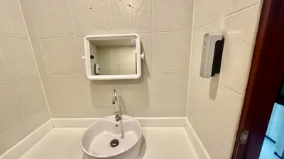 a white bathroom with a sink and a mirror at Abdullah Residence in Patong Beach