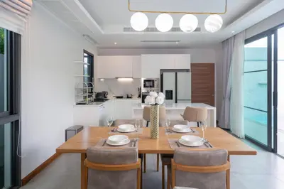 a dining room and kitchen with a table and chairs at Nicky Luxury Private Pool Villa in BangTao Laguna in Laguna Phuket