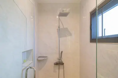 a bathroom with a shower with a toilet and a window at Nicky Luxury Private Pool Villa in BangTao Laguna in Laguna Phuket