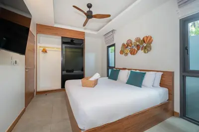 a bedroom with a white bed and a ceiling fan at Nicky Luxury Private Pool Villa in BangTao Laguna in Laguna Phuket