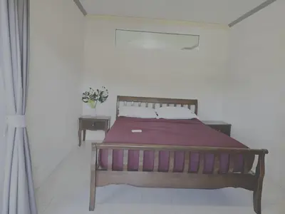 a bedroom with a wooden bed with a purple blanket at WIVA by Woytuk in Patong Beach