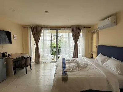 a bedroom with a bed and a desk and a kitchen at Kata Kata Stay in Kata Beach