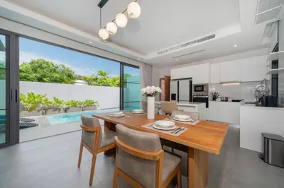 a kitchen and dining room with a wooden table and chairs at Luxury 3BR Pool Villa Relaxation in BangTao Laguna in Laguna Phuket