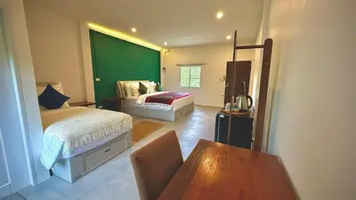 a room with two beds and a table in it at The Simple Place - King and Twin in Klong Muang Beach