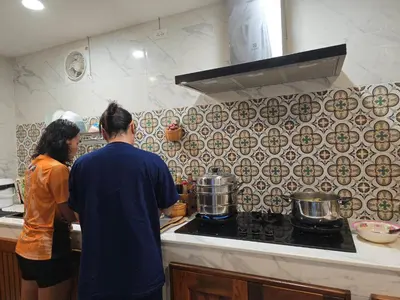 a man and woman preparing food in a kitchen at The Simple Place - King and Twin in Klong Muang Beach