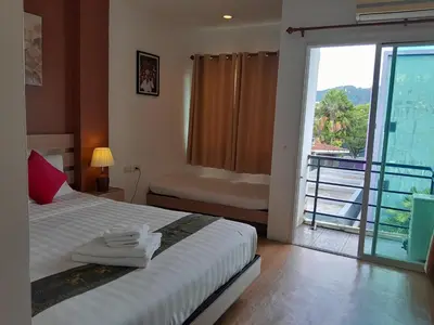 a bedroom with a bed and a balcony with a view at Island Patongbeach Apartments in Patong Beach