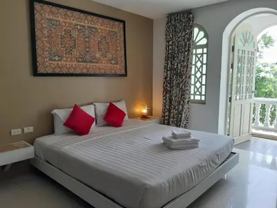 a bedroom with a large bed with red pillows at Island Patongbeach Apartments in Patong Beach