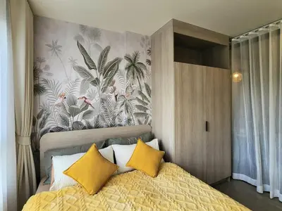 a bedroom with a bed with two yellow pillows at Cozy Palm Haven apartment in Kathu