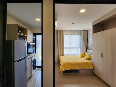 a small room with a bed and a refrigerator at Cozy Palm Haven apartment in Kathu