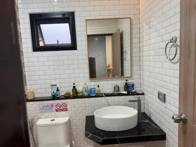 a bathroom with a sink and a toilet and a mirror at Rare Find Penthouse with Private Office and Jungle Mountrain Views in Kamala Beach