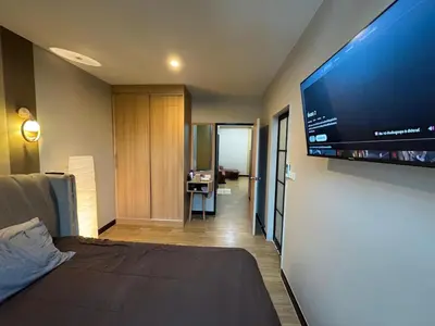 a bedroom with a large flat screen tv on a wall at Rare Find Penthouse with Private Office and Jungle Mountrain Views in Kamala Beach