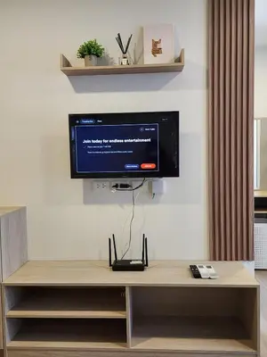 a flat screen tv on a wall in a living room at Cozy Minimalist room in Kathu