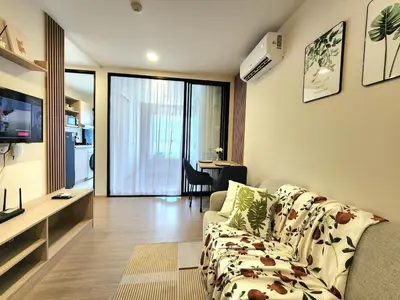 a living room with a couch and a table in a room at Cozy Minimalist room in Kathu