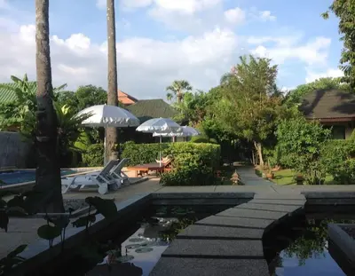 a pool at a resort with umbrellas at Rawai Boutique Resort in Rawai Beach