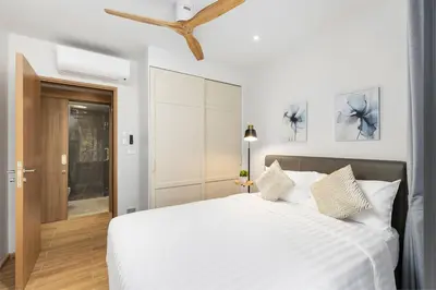 a bedroom with a large bed with white sheets at Bang Tao - Laguna Beachside 3BR Apartment 130 sq m in Bang Tao Beach