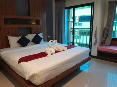 two swans sitting on a bed in a bedroom at Acca Patong Residence in Patong Beach