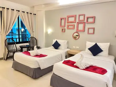 a hotel room with two beds and a balcony at Acca Patong Residence in Patong Beach