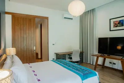 a bedroom with a bed and a desk and a television at 4BR Laguna Golf View Pool Villa Retreats Phuket in Laguna Phuket