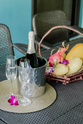 a table with a bottle of wine and a basket of fruit at 4BR Laguna Golf View Pool Villa Retreats Phuket in Laguna Phuket