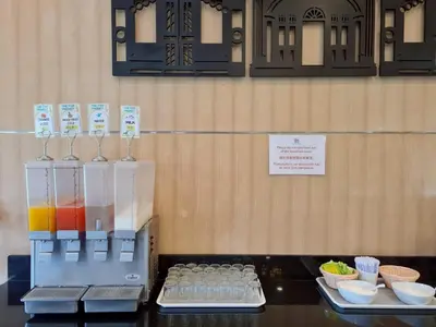 a display case with some drinks and bowls of food at The Par Phuket Hotel in Kathu