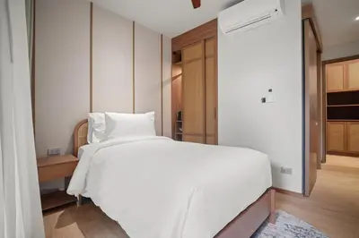 a bedroom with a large white bed and a hallway at Laguna Beachside Block 2 by Banyan Living in Bang Tao Beach