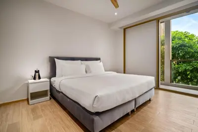 a bedroom with a bed and a large window at Laguna Beachside Block 2 by Banyan Living in Bang Tao Beach