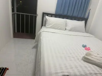 a bed with two stuffed animals sitting on top of it at Cha Cha Guesthouse in Patong Beach