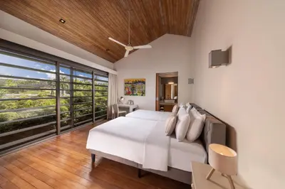 a bedroom with a white bed and a large window at Villa Cielo in Ban Han Pa To