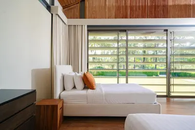 a bedroom with a bed and a large window at Villa Essenza in Ban Han Pa To