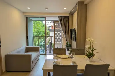 a living room with a table and a couch at 1 Bedroom 108-114 Pool View at Ozone Laguna near Bangtao Beach and Golf in Bang Tao Beach