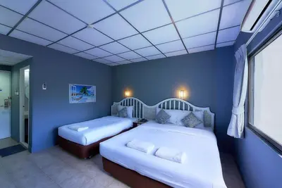 two beds in a room with blue walls at Nora Bukit Hotel in Ban Sam Kong