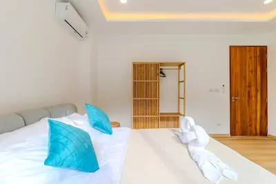 a bedroom with a bed with blue and white pillows at V255 Huge Brand-New 7BR Pool Villa Rooftop View in Kata Beach