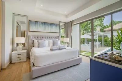 a bedroom with a white bed and a large window at Stylish 3BR Pool Villa trichada Airport Shuttle in Phuket Town