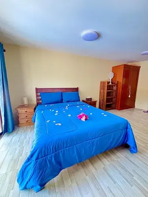 a bedroom with a blue bed with flowers on it at The glade in Ko Yao Noi