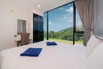 a bedroom with a bed and a large window at Seaview 1 BR Apt at VV Patong C301 near Freedom Beach in Patong Beach