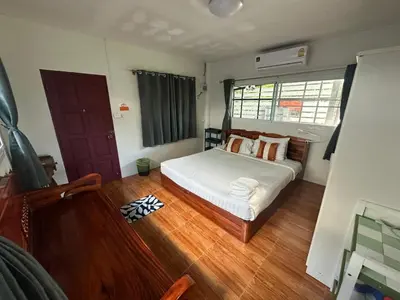 a bedroom with a bed and a wooden floor at Maison Paradise Sea View in Patong Beach
