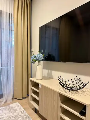 a living room with a large tv on a wall at Cozy apartments for a comfortable stay and accommodation in Phuket Town