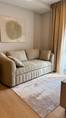 a living room with a couch in front of a window at Cozy apartments for a comfortable stay and accommodation in Phuket Town