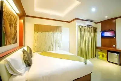 a bedroom with two beds and a television in it at Soul House Patong in Patong Beach