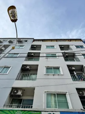 a tall white building with windows and a street light at Soul House Patong in Patong Beach