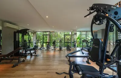 a gym with a bunch of treadmills and machines at Tropical Thai Loft with Koi Pond in Kamala Beach