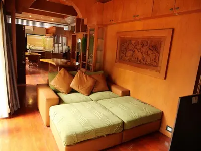 a living room with a couch and a table at Tropical Thai Loft with Koi Pond in Kamala Beach