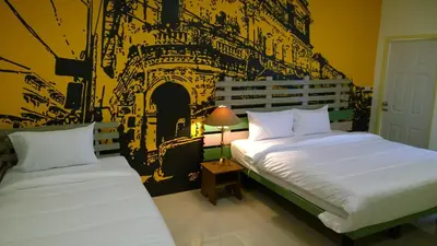 two beds in a room with a black and white wall at The Pho Thong Phuket in Phuket Town