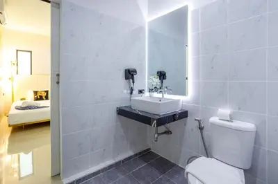 a bathroom with a white toilet and a sink at New! bayfront 2 BR Villa with private pool Nariya V1 - rare find in Phuket in Chalong