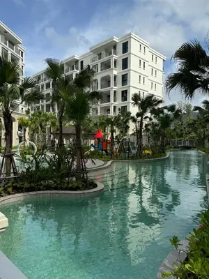 a pool at a resort with palm trees and buildings at Апартаменты у океана пляж Бангтао Title Legendary Bangtao in Bang Tao Beach
