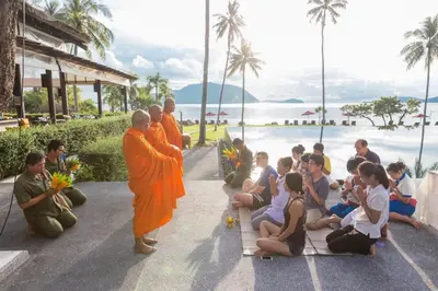 a group of monks standing next to a group of children at The Vijitt - Deluxe Seaview Villa in Ban Saiyuan (1)