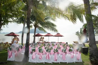 a group of tables with pink chairs and palm trees at The Vijitt - Deluxe Pool Villa in Ban Saiyuan (1)